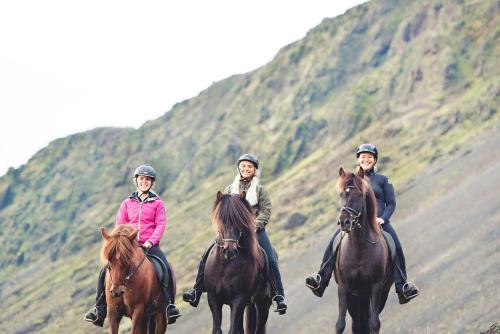 three people riding horses down a dirt road at Akurgerði Guesthouse 6 - Country Life Style in Ölfus