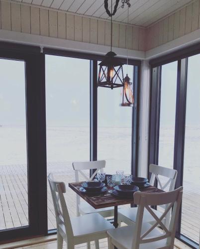 a dining room with a table and chairs with a view of the ocean at Akurgerði Guesthouse 6 - Country Life Style in Ölfus