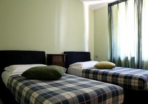 トッリ・デル・ベーナコにあるA Casa di Emy, Lago di Gardaのベッド2台が隣同士に設置された部屋です。