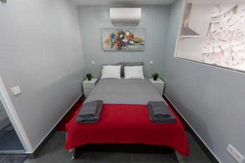 a small room with a bed with a red blanket at WindRose 4 in Madrid