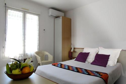 pokój hotelowy z łóżkiem i miską owoców w obiekcie Aubergade w mieście Barbotan-les-Thermes