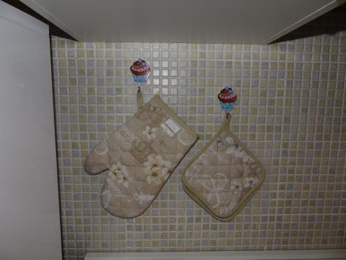 Deux serviettes sont suspendues sur un mur carrelé de la salle de bains. dans l'établissement Casa Eleonora, à Santa Teresa Gallura