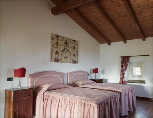 a bedroom with a bed with a pink bedspread at Agrigturismo Monte Cicogna in Moniga