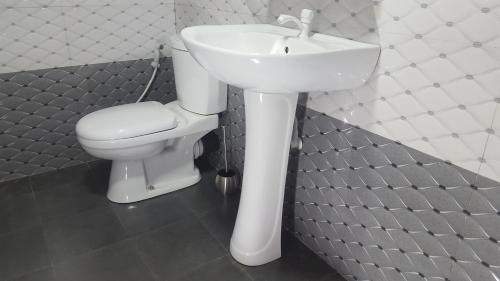 a bathroom with a white sink and a toilet at Tulip Guest Inn in Point Pedro