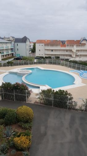 uma grande piscina em frente a alguns edifícios em Résidence MONTE CARLO em Châtelaillon-Plage
