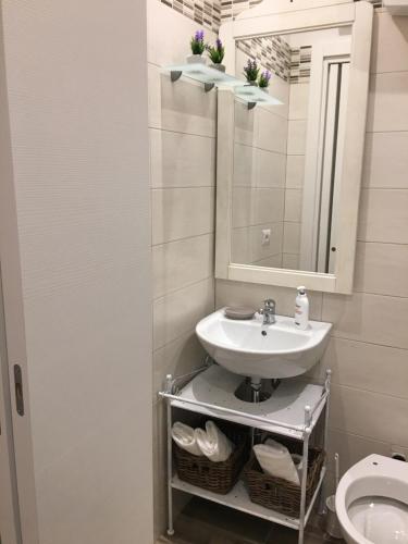 La salle de bains est pourvue d'un lavabo, d'un miroir et de toilettes. dans l'établissement B&B Bari Old Town, à Bari