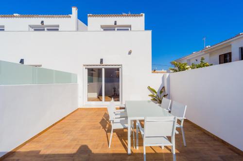 a white dining room with a table and chairs at Apartamentos El Abuelo in Torrevieja