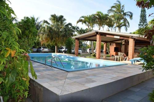 una piscina con patio y un pabellón en Vargas Peruibe Hotel, en Peruíbe