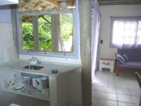a kitchen with a sink and a window at Chalés Musa de Maresias in Maresias