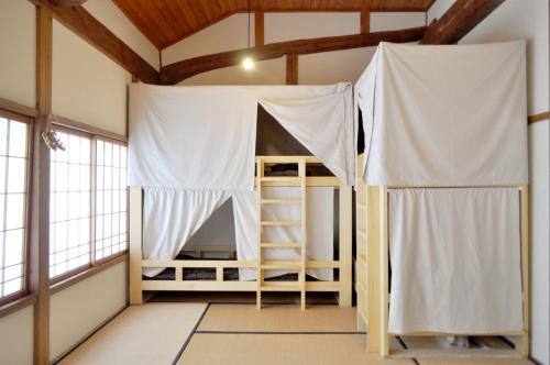 a bedroom with a bunk bed in a room with windows at Guest House Takazuri-KITA in Nanto