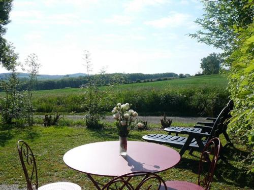 a pink table with a vase of flowers on it at Les Chalets des Mousquetaires in Mirepoix