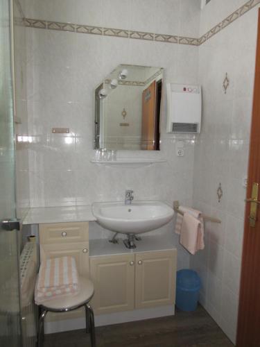 een badkamer met een wastafel, een spiegel en een kruk bij Haus Margarete in Lackenhof