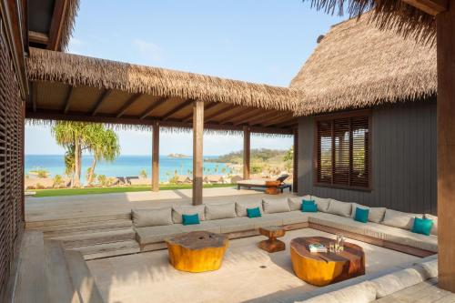 a living room with a couch and a view of the ocean at Six Senses Fiji in Malolo