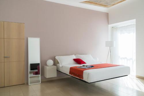ミラノにあるBrera Apartments in Moscovaの白いベッドルーム(ベッド1台、鏡付)