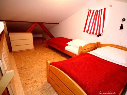 a bedroom with two beds and a red blanket at Ferienwohnung Bornhöft in Burg