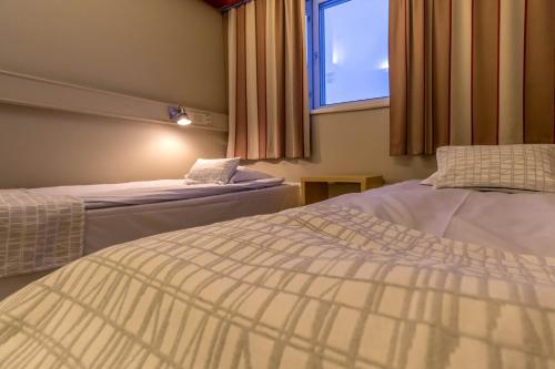 a hotel room with two beds and a window at Santa's Hotel Rudolf in Rovaniemi