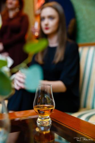 a woman sitting next to a glass of alcohol at Hotel Select in Iaşi