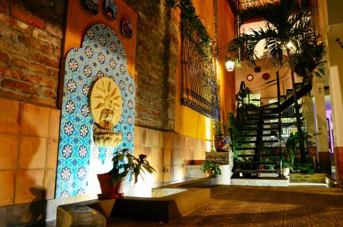 a lobby with a staircase and a blue tile wall at Magic Garden House in Cali