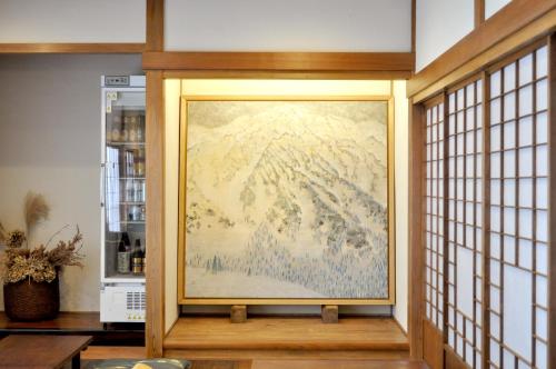 a large painting on a wall in a room at Guest House Takazuri-KITA in Nanto