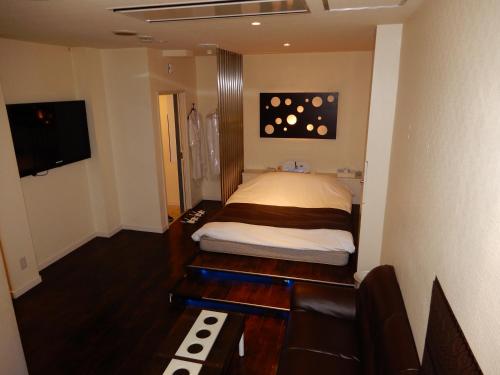 a bedroom with a bed and a couch and a television at Hotel Shindbad Aomori -Love Hotel- in Aomori