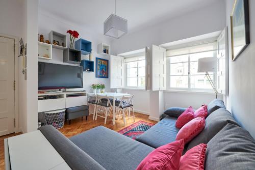 a living room with a couch and a table at Lisbon Haven - By the METRO with AC in Lisbon