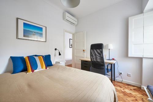 a bedroom with a bed and a desk in it at Lisbon Haven - By the METRO with AC in Lisbon