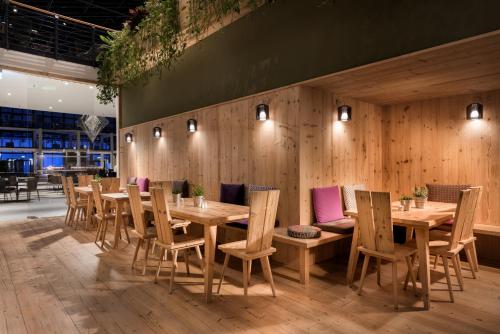 a restaurant with wooden walls and wooden tables and chairs at Estrel Berlin in Berlin