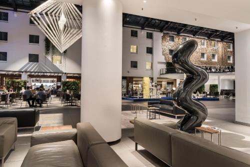 a lobby with couches and a sculpture of a snake at Estrel Berlin in Berlin