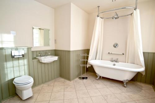 a bathroom with a tub and a toilet and a sink at The Cuckoo Brow Inn in Far Sawrey