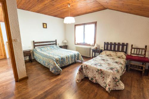 een slaapkamer met 2 bedden, een tafel en een raam bij Chalet Riba in Arinsal