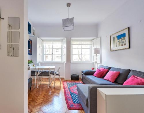 a living room with a couch and a table at Lisbon Haven - By the METRO with AC in Lisbon