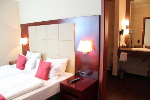 a hotel room with a bed and a sink at Hotel Amaris Bremerhaven in Bremerhaven