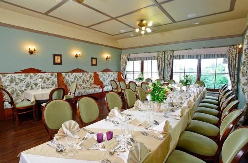 a dining room with white tables and chairs and tablesearcher at Villa Estera - Hotel & Restauracja in Michałowice