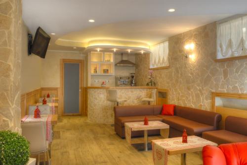 a living room with a couch and tables and a kitchen at Hotel Belvedere in Roccaraso
