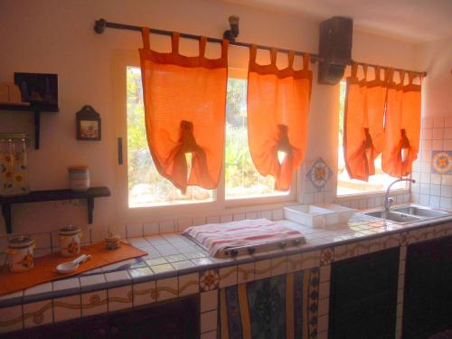 a kitchen with a counter with two windows and a sink at A Due Passi Dal Mare Con Piscina in Fontane Bianche