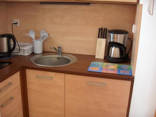 a kitchen counter with a sink and a coffee maker at Apartament Nowowiejskiego in Świnoujście