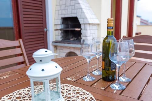 ノヴァリャにあるMaru Apartmentsのワイン1本とワイングラス3杯