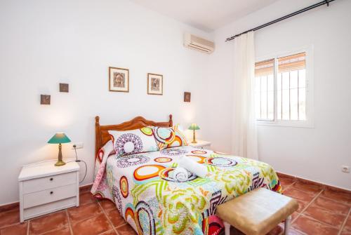 ein Schlafzimmer mit einem Bett mit einer bunten Bettdecke in der Unterkunft Cubo's Finca La Viña Angulo in Alhaurín de la Torre