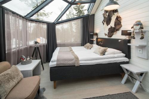a bedroom with a bed in front of a window at Santa's Igloos Arctic Circle in Rovaniemi