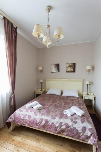 a bedroom with a bed and a chandelier at Villa Estera - Hotel & Restauracja in Michałowice