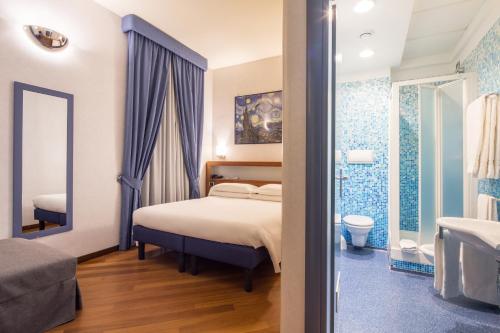 a bedroom with a bed and a bathroom at Best Western Plus Hotel Plaza in Naples