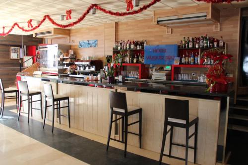a bar with black stools in a restaurant at Hotel Vazquez Diaz in Nerva
