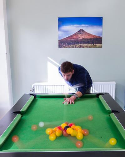 a man playing pool on a pool table at Cote Ghyll Mill at Osmotherley in Osmotherley