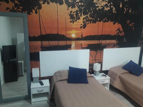 a room with two beds with a painting on the wall at Hostal Africa Do Sul in Lisbon