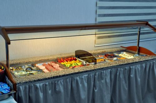 a buffet with meat and vegetables on a table at Potaissa Hotel in Turda