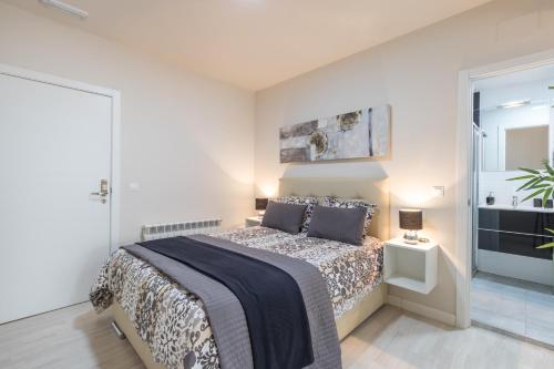 um quarto com uma cama grande e uma porta de vidro deslizante em Apartamentos Recogidas em Granada