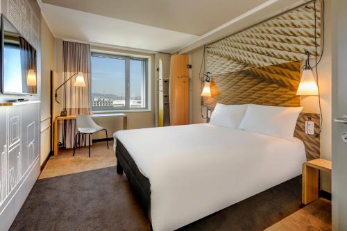 una camera d'albergo con un grande letto e una finestra di ibis Manchester Centre Princess Street a Manchester