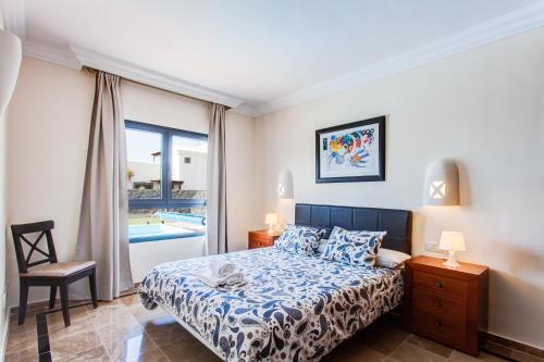 1 dormitorio con cama y ventana con piscina en Hipoclub Villas, Zafiro 34 en Playa Blanca