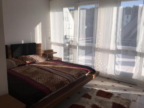 a bedroom with a bed and a large window at EMC Maisonette in Aidlingen