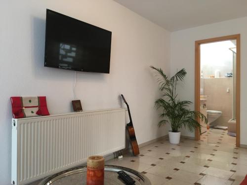 a living room with a flat screen tv on the wall at EMC Maisonette in Aidlingen